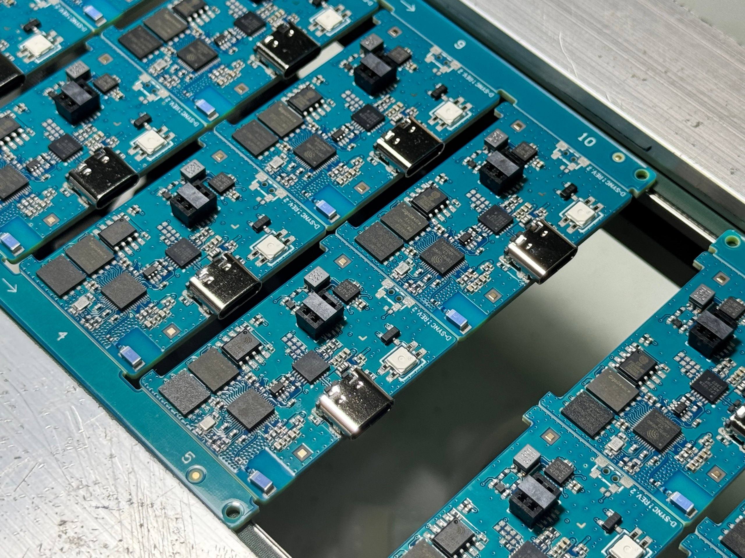 Assembled D-Sync Rev. 2 board panels laid in an aluminium tray for quality-control inspection.