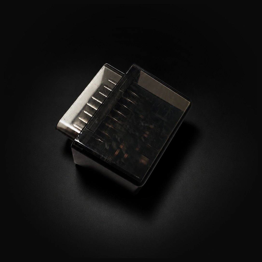 D-Sync D1 OBD-II device in a smoked translucent housing, product photograph on a black background.