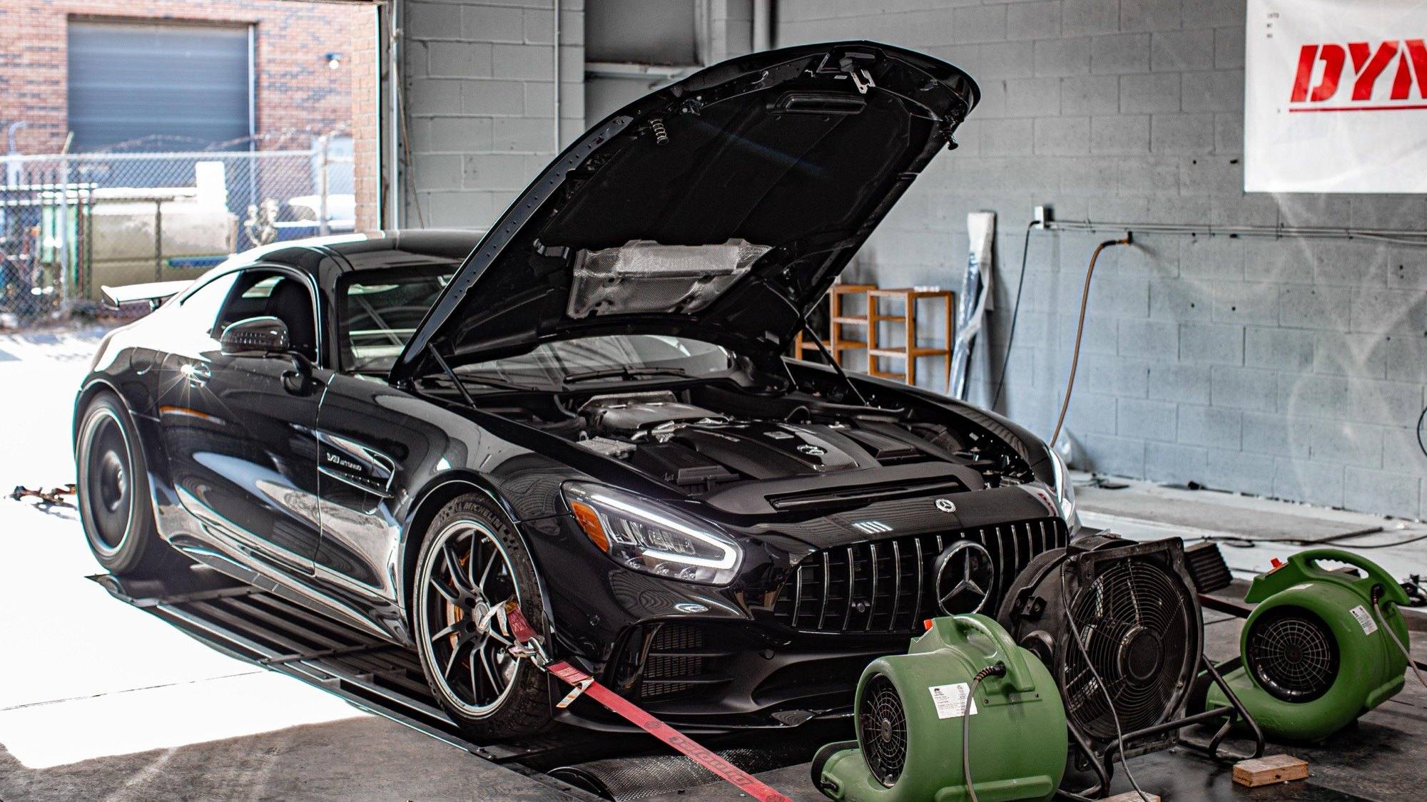 Mercedes-AMG GT strapped to a Dynojet chassis dynamometer with the bonnet open and cooling fans placed in front of the car.