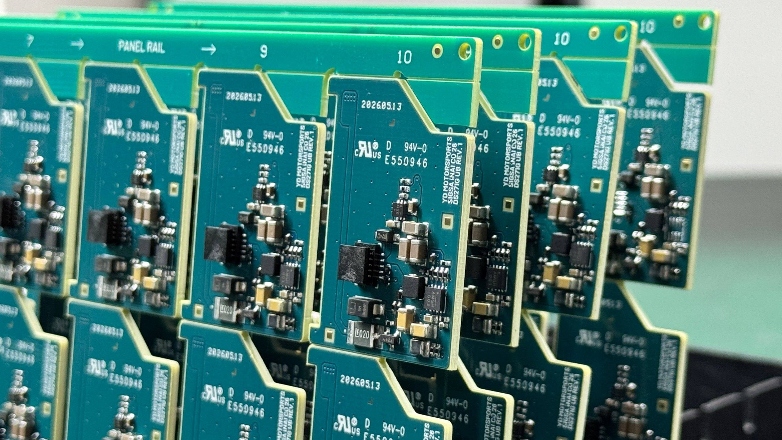 Panels of assembled D-Sync programme circuit boards standing in a rack, each carrying the YD Motorsports silkscreen, date code and UL 94V-0 marking.