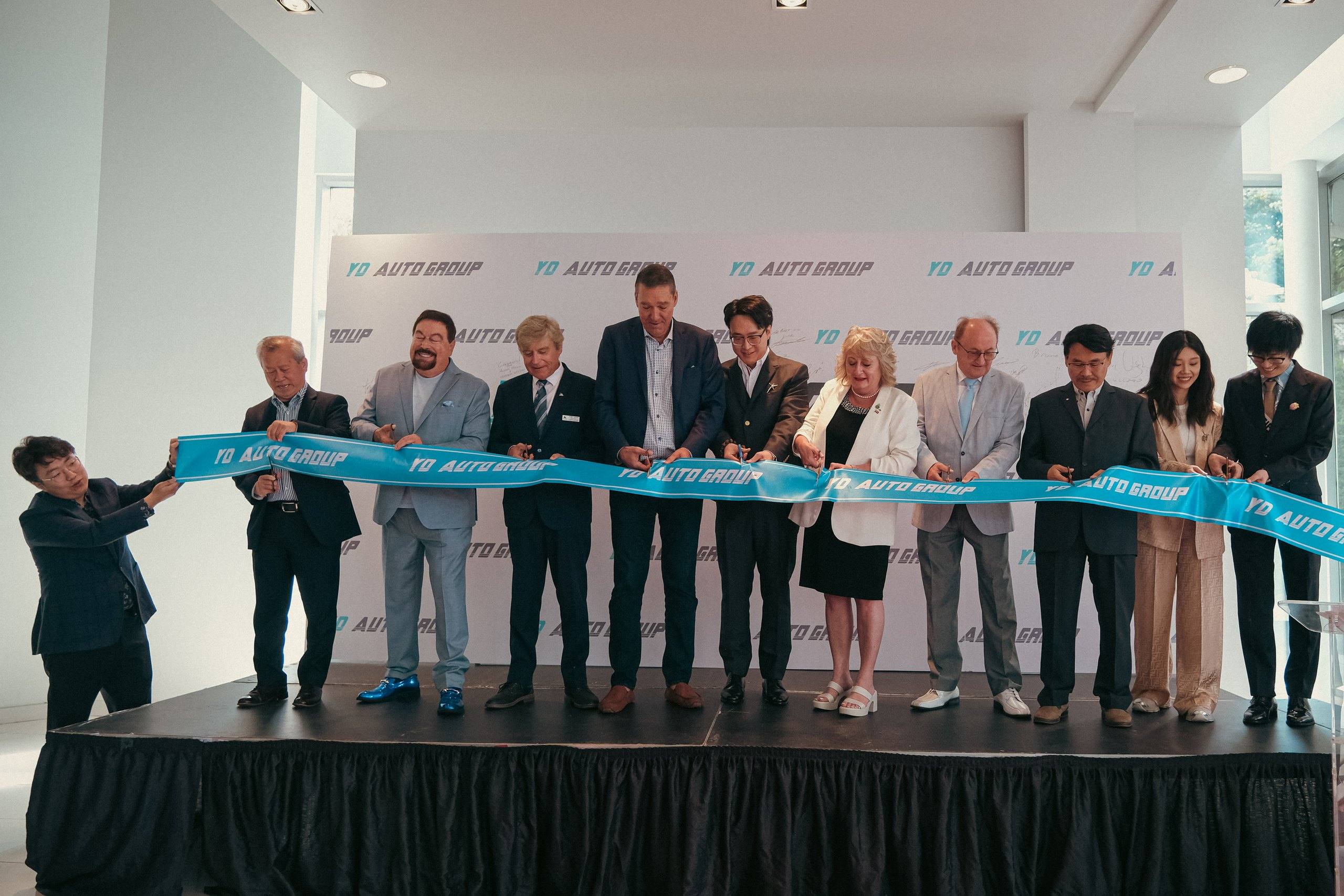 Ribbon-cutting ceremony at the opening of the YD Auto Group headquarters in Newmarket on July 18, 2024, with invited officials, guests and company leadership on stage.
